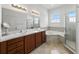 Bright bathroom features a tub, glass shower, double sinks, and tile floors at 1547 Cordgrass Way, Lakeland, FL 33813