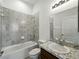 Bathroom with gray tile shower, a single sink with granite countertop and white toilet at 1547 Cordgrass Way, Lakeland, FL 33813