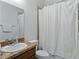 Bathroom with granite countertop, wood vanity, white shower curtain, and white toilet at 1547 Cordgrass Way, Lakeland, FL 33813