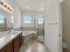 Bright bathroom features a soaking tub, glass shower and a double-sink vanity at 1547 Cordgrass Way, Lakeland, FL 33813