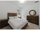 Bedroom with wood bed frame, two nightstands, and dark wood dresser with round mirror at 1547 Cordgrass Way, Lakeland, FL 33813
