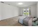 Spacious bedroom with light-colored carpet, French doors, and neutral walls at 1547 Cordgrass Way, Lakeland, FL 33813