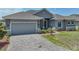 A well kept home featuring stone accents, a gray driveway and manicured lawn at 1547 Cordgrass Way, Lakeland, FL 33813