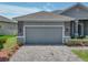 A gray garage door, brick driveway and manicured lawn create great curb appeal at 1547 Cordgrass Way, Lakeland, FL 33813