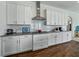 Modern kitchen with granite countertops, white cabinets and stainless-steel range hood at 1547 Cordgrass Way, Lakeland, FL 33813