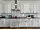 Modern kitchen with granite countertops, white cabinets and stainless-steel range hood at 1547 Cordgrass Way, Lakeland, FL 33813