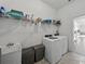 Practical laundry room equipped with shelving, washer, dryer, and a utility sink at 1547 Cordgrass Way, Lakeland, FL 33813