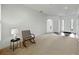Bright living room with carpet flooring, white walls, and a view of the front entrance at 1547 Cordgrass Way, Lakeland, FL 33813