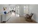 Bright living room featuring a rocking chair, white trim, and view to another living space at 1547 Cordgrass Way, Lakeland, FL 33813