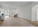Neutral living room with carpet, white walls, and views to the patio and hallway at 1547 Cordgrass Way, Lakeland, FL 33813