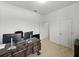 Bright office with two Dell monitors on a wood desk with white walls and neutral carpet at 1547 Cordgrass Way, Lakeland, FL 33813