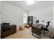 Home office features a window, bookshelf, dark wood desk, dresser, and neutral carpet at 1547 Cordgrass Way, Lakeland, FL 33813