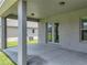 Spacious covered patio with concrete flooring, exterior lighting, and access to the home through French doors at 1547 Cordgrass Way, Lakeland, FL 33813