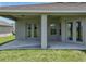 Covered patio area with access to the home through French doors, and a view of the landscaped backyard at 1547 Cordgrass Way, Lakeland, FL 33813