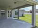 The covered patio offers outdoor living space, featuring concrete flooring and access to the home's landscaped backyard at 1547 Cordgrass Way, Lakeland, FL 33813