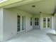 Covered patio featuring concrete flooring, access to the home through French doors, and outdoor lighting at 1547 Cordgrass Way, Lakeland, FL 33813