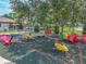Community playground includes swings, spring riders, seesaw, and play seating all in a fenced-in green space at 1547 Cordgrass Way, Lakeland, FL 33813