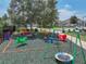 Community playground offers seesaw, swings, spring riders, and ample seating under a large shade tree at 1547 Cordgrass Way, Lakeland, FL 33813