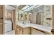 Vintage bathroom featuring floral wallpaper, a vanity with sink, and a large mirror at 1602 Tally Ho Dr, Lakeland, FL 33810