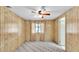 Bedroom features wood paneling and neutral carpet at 1602 Tally Ho Dr, Lakeland, FL 33810