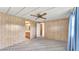Bedroom with patterned carpet, light-colored wood walls and ceiling fan at 1602 Tally Ho Dr, Lakeland, FL 33810