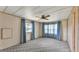 Bedroom with patterned carpet, light-colored walls, ceiling fan and several windows at 1602 Tally Ho Dr, Lakeland, FL 33810