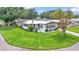 Charming home with a well-kept lawn, mature tree, and classic American flag at 1602 Tally Ho Dr, Lakeland, FL 33810