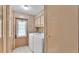 Functional laundry room with washer, dryer, overhead cabinets, and exterior door at 1602 Tally Ho Dr, Lakeland, FL 33810