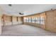 Spacious living room with wood paneled walls, built-in shelving, and lots of natural light at 1602 Tally Ho Dr, Lakeland, FL 33810