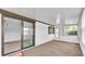 Enclosed sunroom featuring neutral carpet, sliding glass door and multiple windows at 1602 Tally Ho Dr, Lakeland, FL 33810