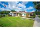 A brick community clubhouse on a well-manicured lawn flies an American flag on a sunny day at 1608 Colonnades N Cir, Lakeland, FL 33811