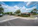 Community entrance featuring a gated entry and manicured landscaping under a sunny sky at 1608 Colonnades N Cir, Lakeland, FL 33811