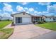 Inviting home with a screened-in porch and an attached garage with a wide driveway at 1608 Colonnades N Cir, Lakeland, FL 33811