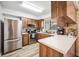 Charming kitchen featuring stainless steel appliances, wood cabinets, and light countertops at 1608 Colonnades N Cir, Lakeland, FL 33811