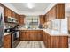 Bright kitchen featuring stainless steel appliances, wood cabinets, and light countertops at 1608 Colonnades N Cir, Lakeland, FL 33811