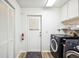 Functional laundry room with modern washer and dryer, storage cabinets, and convenient access to the backyard at 1608 Colonnades N Cir, Lakeland, FL 33811