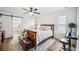 Bright main bedroom with a wooden bed frame, ceiling fan, and a sliding barn door to the ensuite bathroom at 1608 Colonnades N Cir, Lakeland, FL 33811