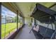 Relaxing screened-in porch with comfortable swing seating, ceiling fans, and a view of the lush backyard at 1608 Colonnades N Cir, Lakeland, FL 33811