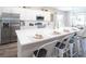 Modern kitchen with stainless steel appliances, expansive island with seating, and sleek white cabinetry at 1826 Daystar Dr, Haines City, FL 33844