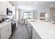Contemporary kitchen features white cabinets, stainless steel appliances, a spacious island, and stylish lighting at 1826 Daystar Dr, Haines City, FL 33844