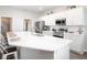 Open kitchen with white cabinets, a stainless steel fridge, a large quartz island, and modern appliances at 1826 Daystar Dr, Haines City, FL 33844