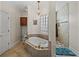 A luxurious bathroom displays a soaking tub with gold hardware and a glass block window providing natural light at 184 Melissa Trl, Auburndale, FL 33823
