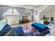 Inviting bonus room featuring blue sofas, colorful rug, and plenty of natural light from large windows at 184 Melissa Trl, Auburndale, FL 33823