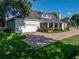 Side view of the home with a view of the screened-in porch, brick driveway, and garage at 184 Melissa Trl, Auburndale, FL 33823