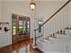 Inviting foyer featuring gleaming hardwood floors, a wooden door and elegant staircase at 184 Melissa Trl, Auburndale, FL 33823
