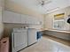 Laundry room featuring tile floors, storage cabinets and modern washer and dryer at 184 Melissa Trl, Auburndale, FL 33823