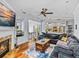 Open living room with fireplace, ceiling fan, wood floors, and access to dining area at 184 Melissa Trl, Auburndale, FL 33823
