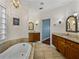 Luxurious main bathroom with a soaking tub, granite countertops, tiled floors and double sinks at 184 Melissa Trl, Auburndale, FL 33823