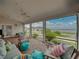 Inviting screened-in porch featuring brick flooring and comfortable seating with stunning views of the water at 184 Melissa Trl, Auburndale, FL 33823
