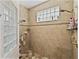 An inviting bathroom features tiled walls, glass block window, and dual shower heads for a spa-like experience at 184 Melissa Trl, Auburndale, FL 33823